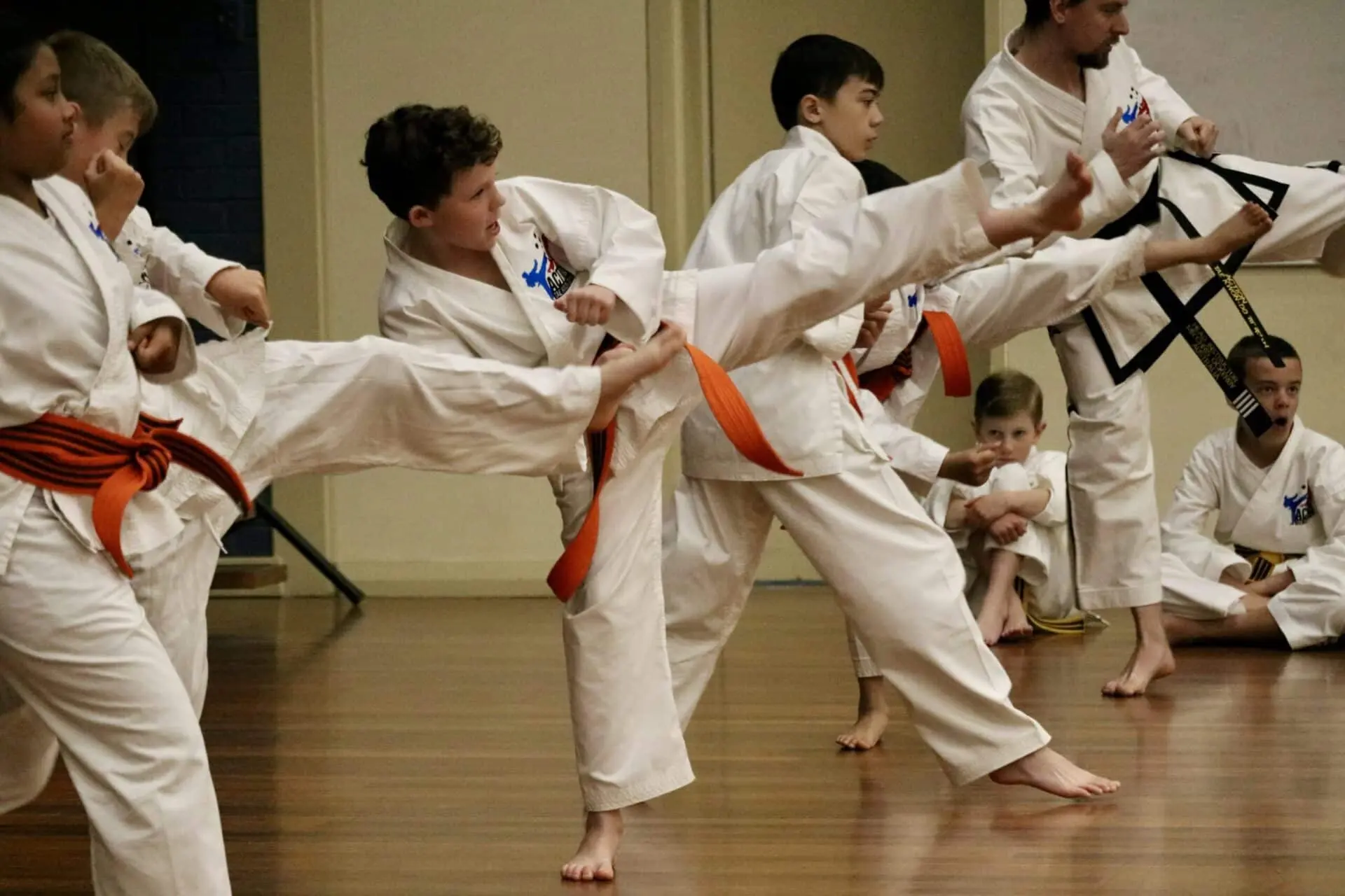 Action Tae Kwon-Do grading photo of kids kicking.